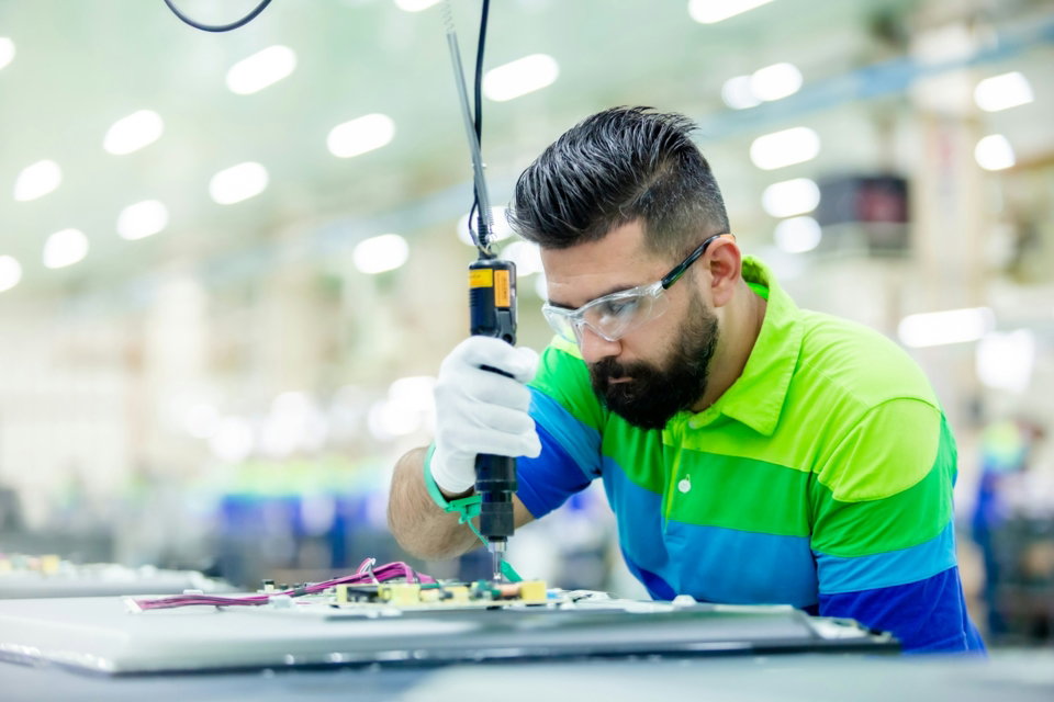 a-man-in-a-factory-working-on-a-piece-of-equipment.jpg a man in a factory working on a piece of equipment
