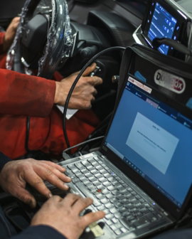 A man sitting in a car using a laptop computer
