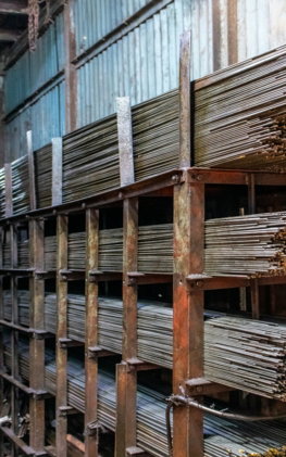 Metal rods stacked on industrial shelving units.